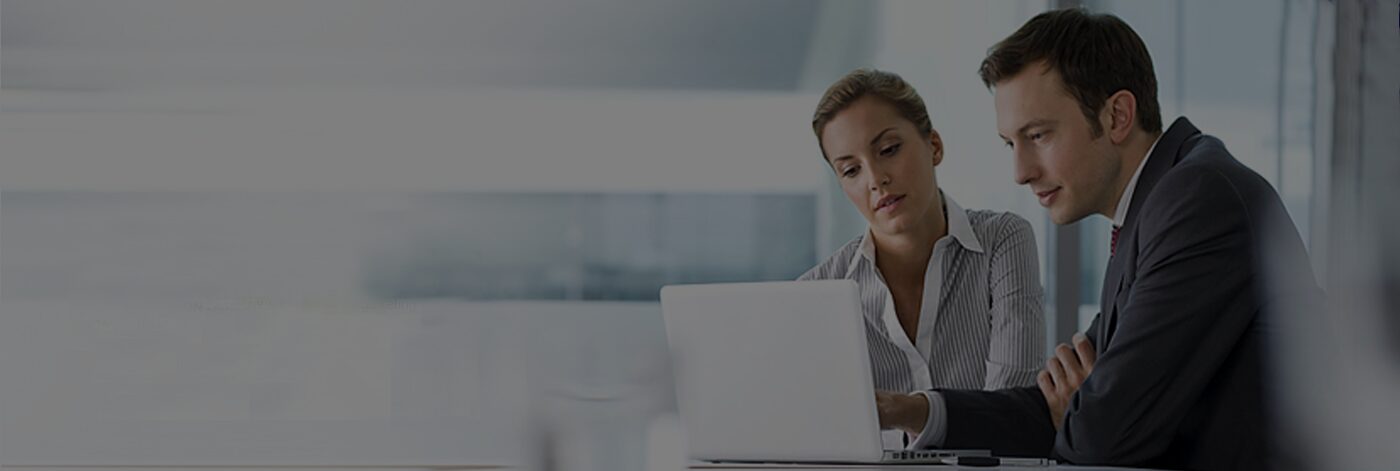 Two professionals working on a laptop.